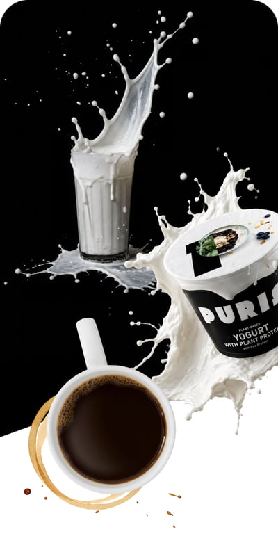 Glass of milk spilling over, protein yogurt container, and cup of coffee