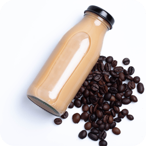 Bottled protein coffee beverage laying next to coffee beans